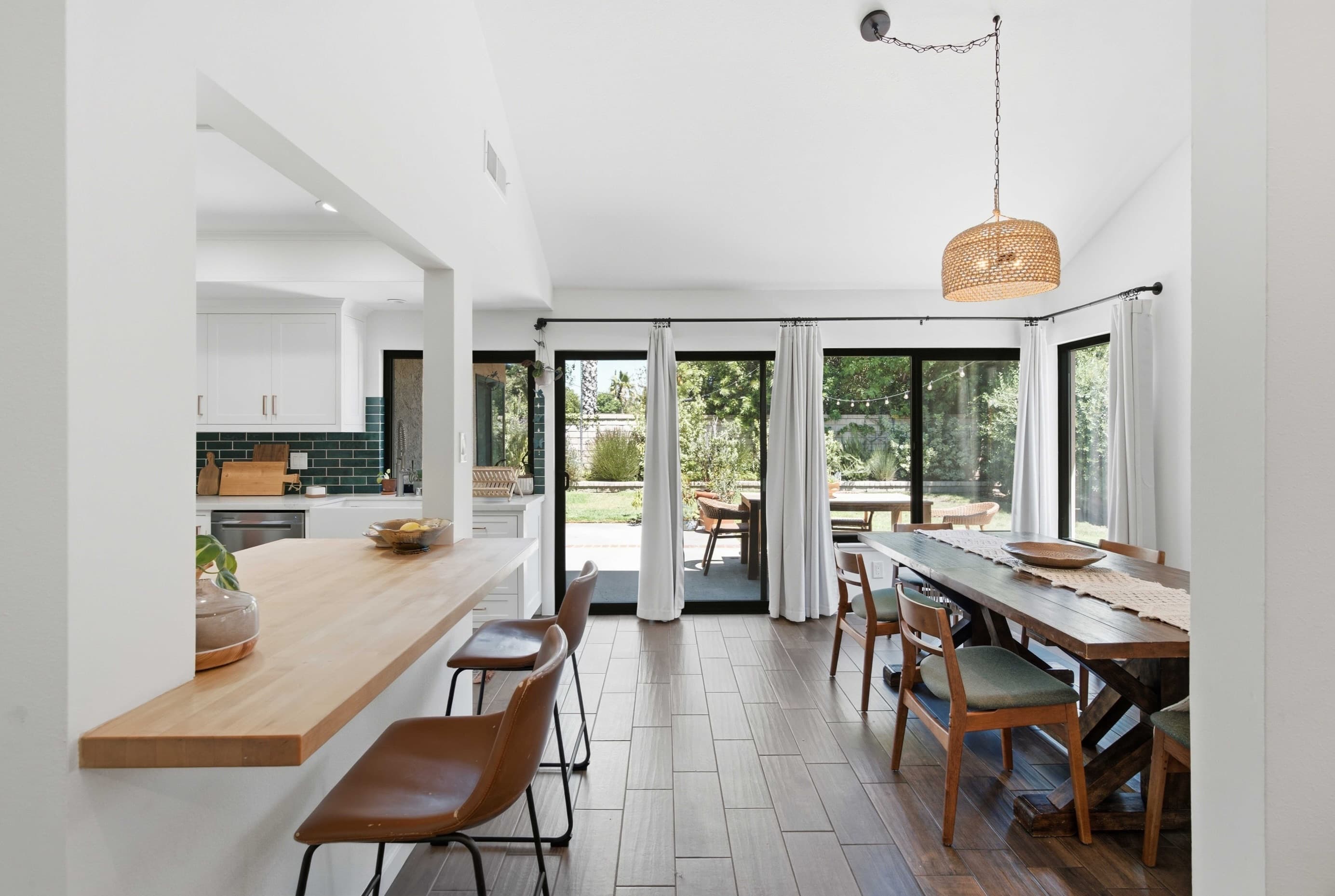 Bright open-plan kitchen and dining room opening onto a Southern California backyard